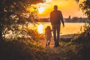 Father and child walking by the lake at sunset | Protecting Your Children’s Inheritance in Divorce
